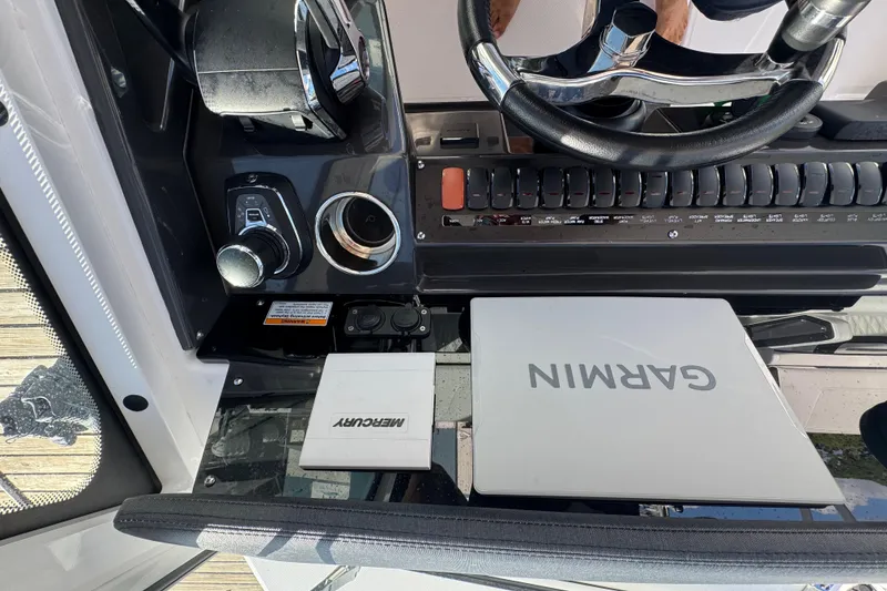 Slide: The Image of Helm of 2025 Blackfin 272 DC boat with navigation system, steering wheel, and water view. - 30