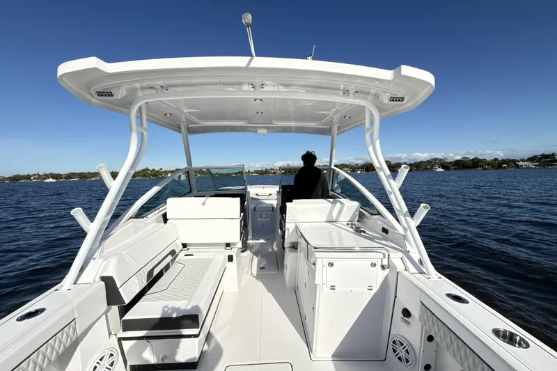 Slide: The Image of 2025 Blackfin 272 DC boat dashboard with navigation system, steering wheel, and water view. - 31