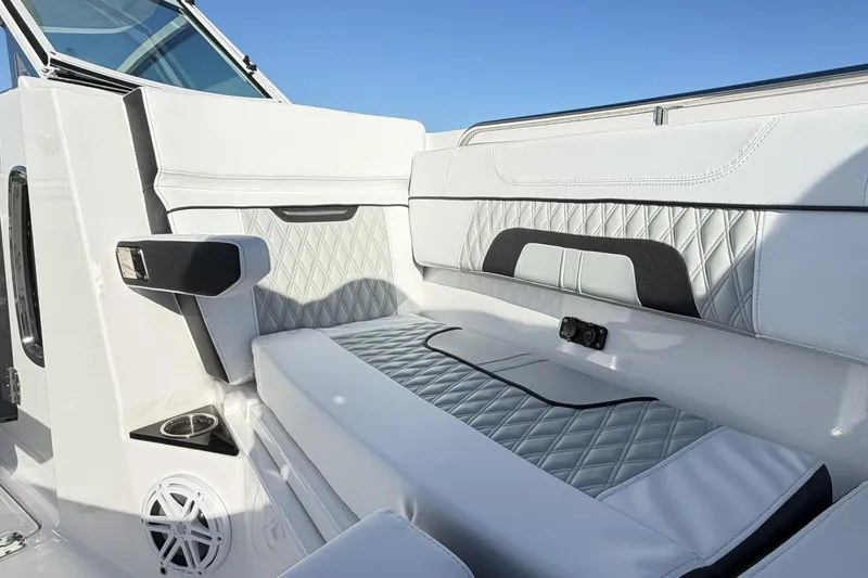 Slide: The Image of 2025 Blackfin 272 DC boat interior with sleek seating and storage, under a clear blue sky. - 53