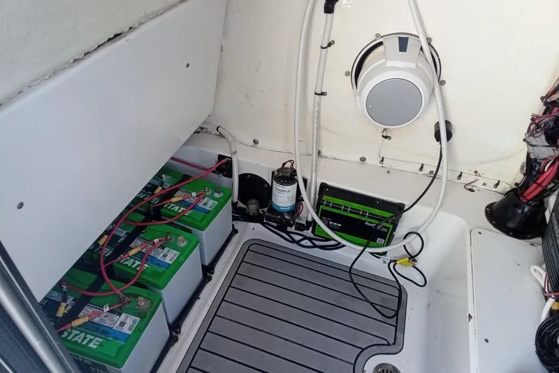 Slide: The Image of 2023 Tidewater 2700 Carolina Bay boat battery compartment with wiring and equipment. - 22