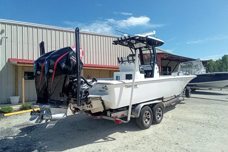 Slide: The Image of 2023 Tidewater 2700 Carolina Bay boat with dual engines on a trailer, outdoors. - 25