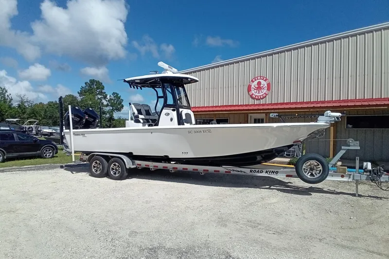 Slide: The Image of 2023 Tidewater 2700 Carolina Bay boat on trailer outside a building under a blue sky. - 26