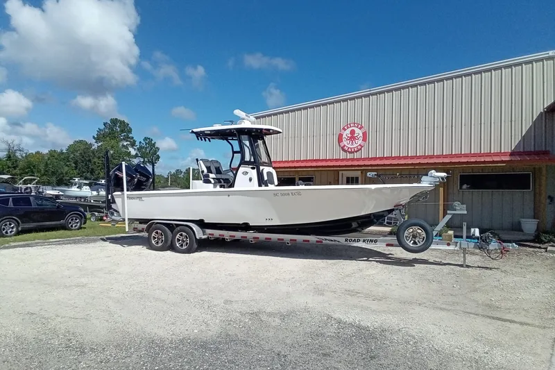 Slide: The Image of 2023 Tidewater 2700 Carolina Bay boat on trailer outside a dealership under a clear blue sky. - 28