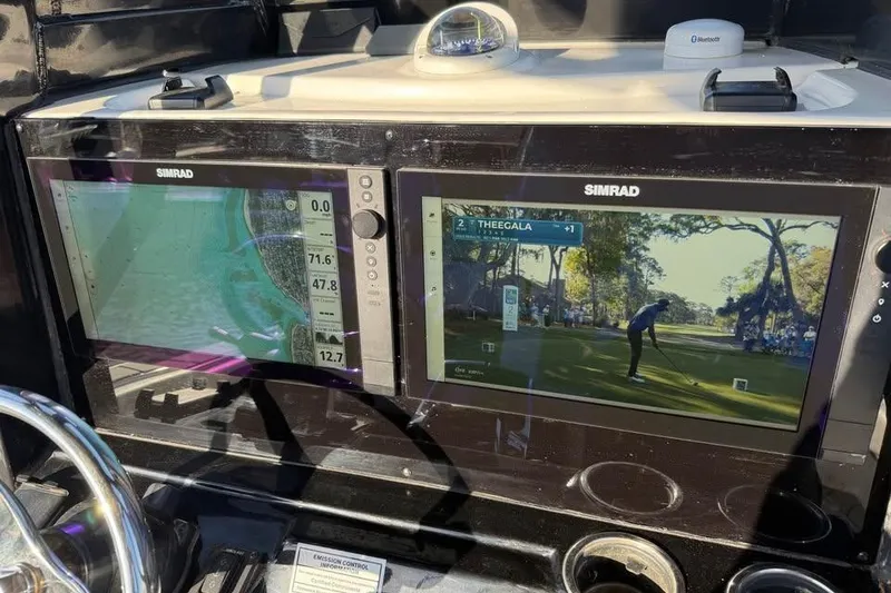 Slide: The Image of Simrad displays on 2023 Tidewater 2700 Carolina Bay boat, showing navigation and golf broadcast. - 32