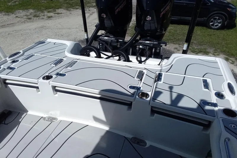 Slide: The Image of 2023 Tidewater 2700 Carolina Bay boat deck with storage compartments and dual engines. - 9