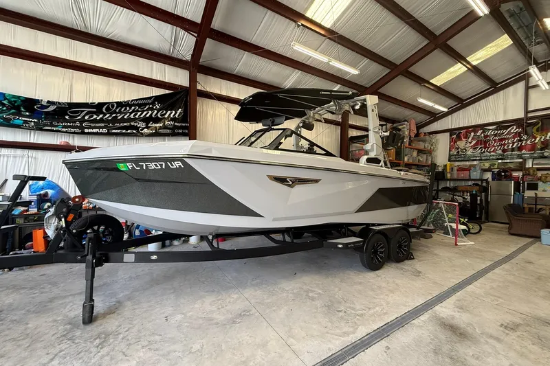 Slide: The Image of 2024 Nautique Super Air Nautique S23 boat in a garage, on a trailer. - 11