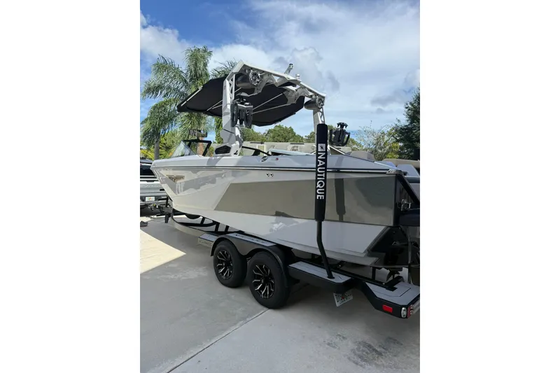 Slide: The Image of 2024 Nautique Super Air Nautique S23 boat on trailer, parked outdoors. - 19