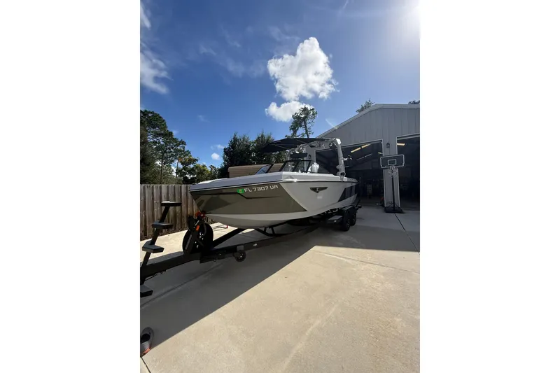 Slide: The Image of 2024 Nautique Super Air Nautique S23 boat on trailer, sunny day, garage background. - 20