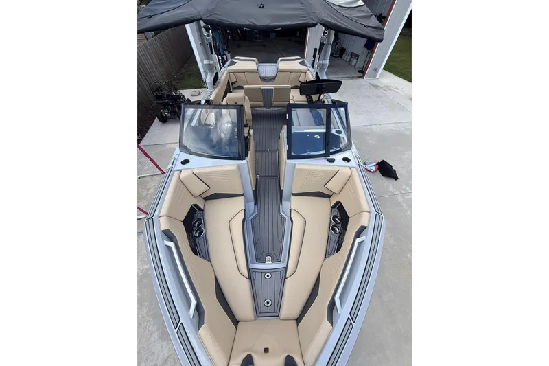 Slide: The Image of 2024 Nautique Super Air Nautique S23 boat interior with beige seating and sleek design. - 5