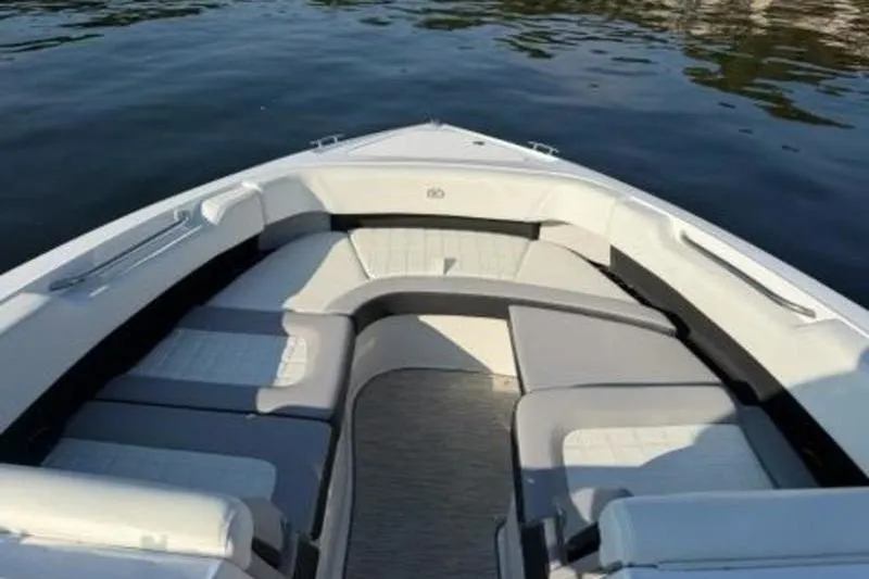 Slide: The Image of 2024 Cobalt R30 boat interior with cushioned seating on calm water. - 11