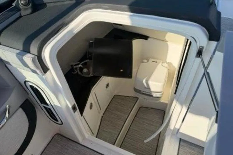 Slide: The Image of 2024 Cobalt R30 boat interior cabin with compact toilet and storage space. - 12
