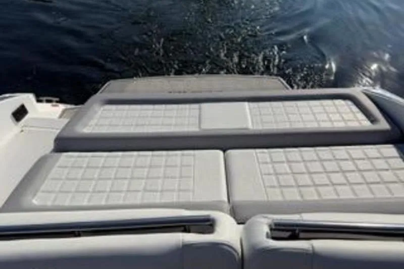 Slide: The Image of 2024 Cobalt R30 boat with cushioned sun deck on water. - 13