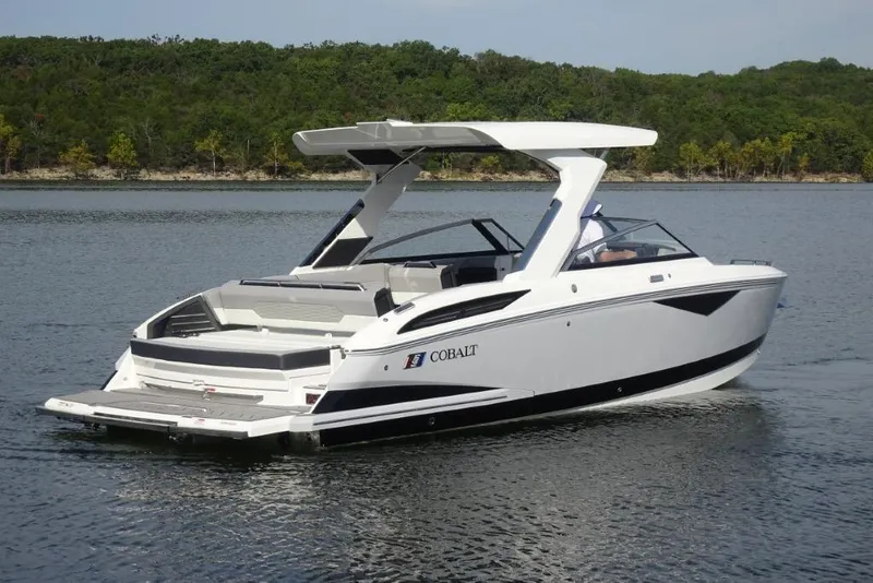 Slide: The Image of 2026 Cobalt A29 boat on a serene lake with lush green shoreline. - 2