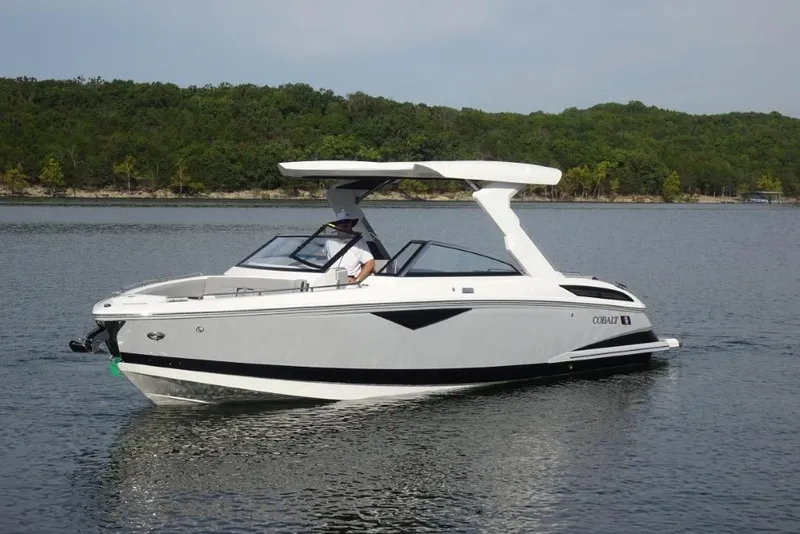 Slide: The Image of 2026 Cobalt A29 boat cruising on a serene lake with lush green shoreline. - 5