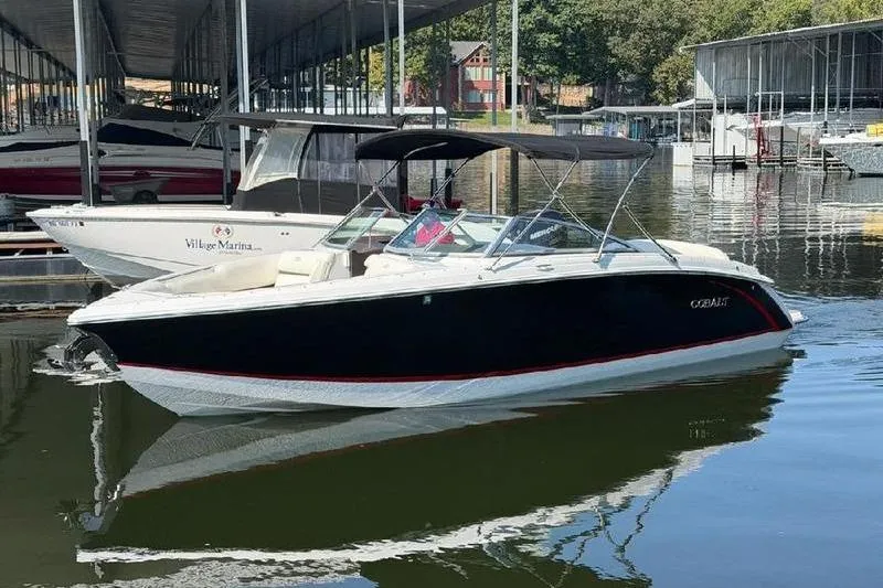 The Image of 2015 Cobalt R7 boat docked in marina, featuring sleek black and white design. - 0