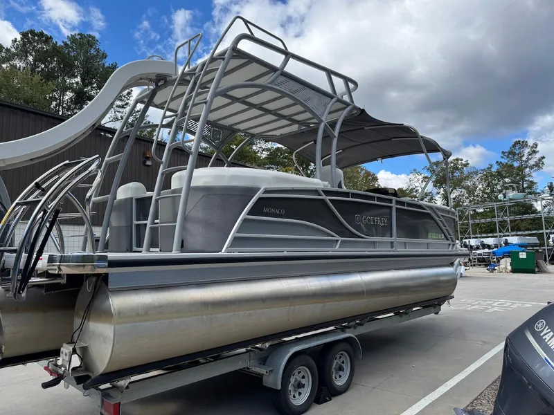 Slide: The Image of 2023 Godfrey Monaco 255 SD pontoon boat on trailer, under cloudy sky. - 6