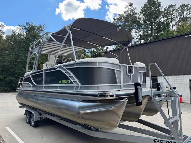 Slide: The Image of 2023 Godfrey Monaco 255 SD pontoon boat on trailer, parked outdoors. - 7