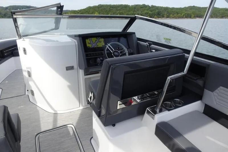 Slide: The Image of 2026 Cobalt A29 boat interior with modern dashboard and steering, on a serene lake. - 15