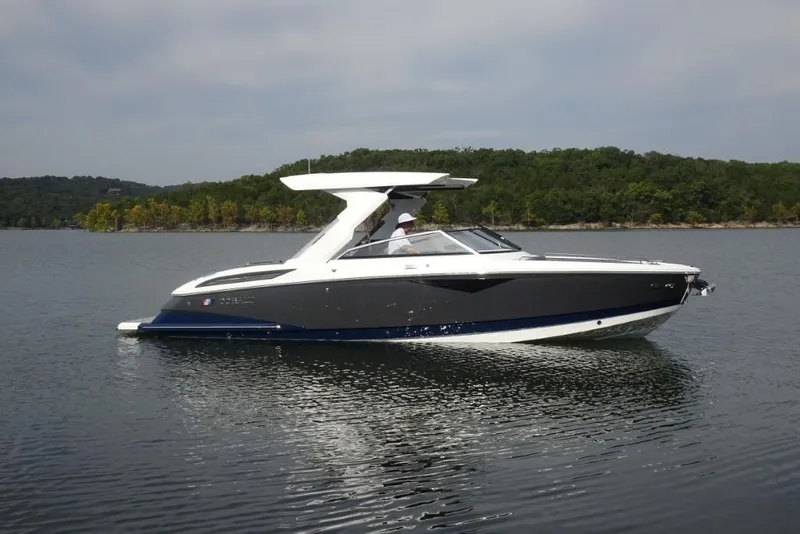 Slide: The Image of 2026 Cobalt A29 boat cruising on a serene lake with forested shoreline. - 2