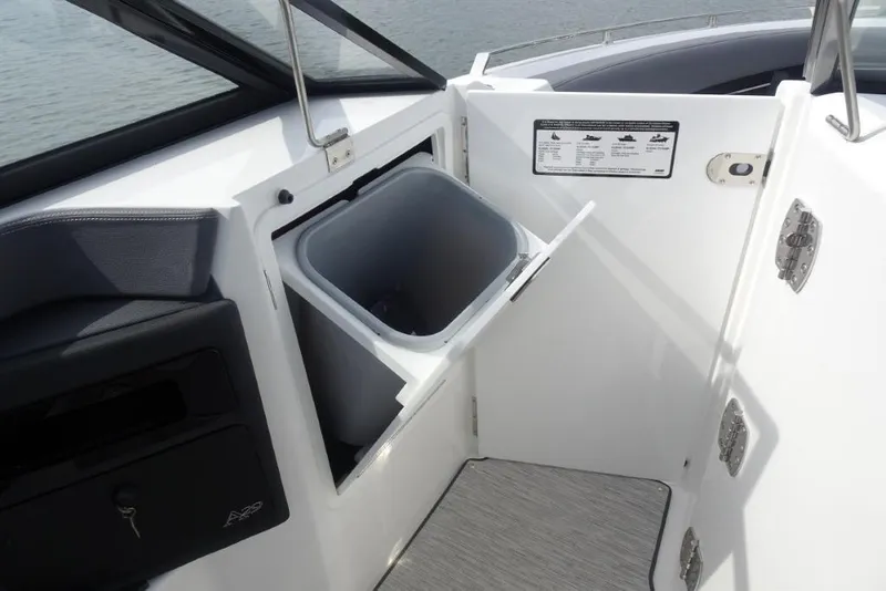 Slide: The Image of 2026 Cobalt A29 boat interior with storage compartment and trash bin. - 23