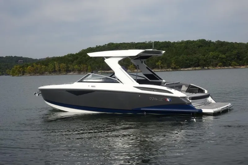 Slide: The Image of 2026 Cobalt A29 boat on a serene lake with lush green shoreline. - 6