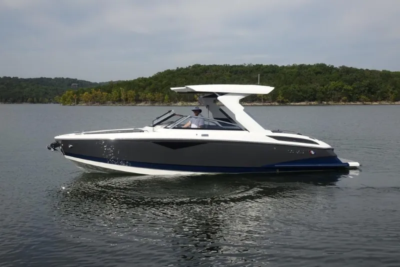 Slide: The Image of 2026 Cobalt A29 boat cruising on a serene lake with lush green shoreline. - 7