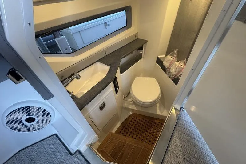 Slide: The Image of 2024 Cobalt R35 boat bathroom with sink, toilet, and wooden flooring. - 12