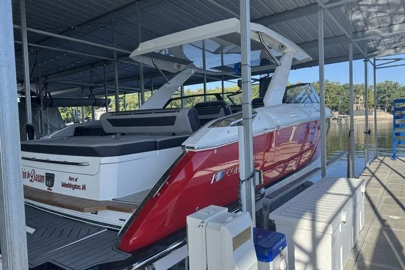 Slide: The Image of 2024 Cobalt R35 boat docked in a covered marina, featuring sleek red and white design. - 4