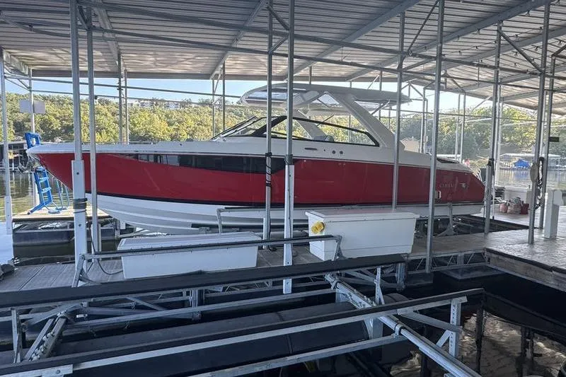 Slide: The Image of 2024 Cobalt R35 boat in red, docked under a covered marina. - 6
