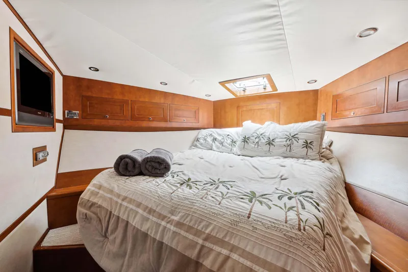 Slide: The Image of Luxurious cabin interior of 2012 Bertram Custom Sportfish with cozy bedding and wooden accents. - 13