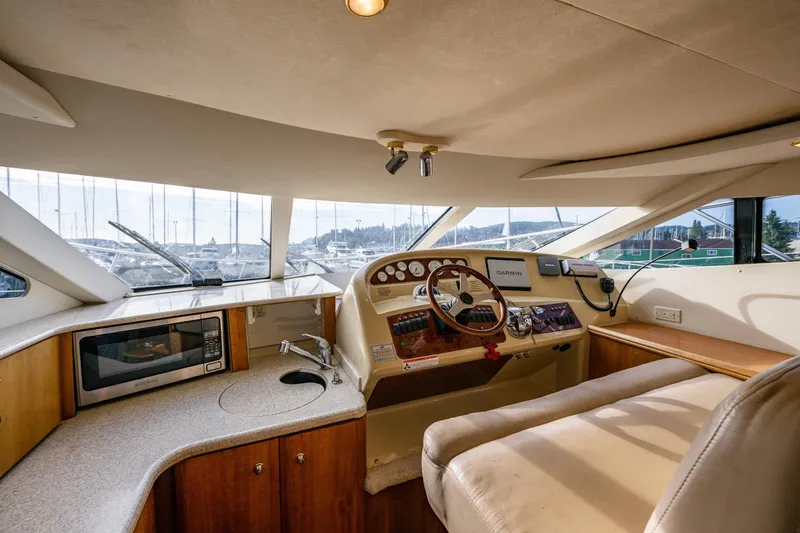 Slide: The Image of Interior of 2001 Silverton 410 Sport Bridge yacht with helm, microwave, and seating area. - 15