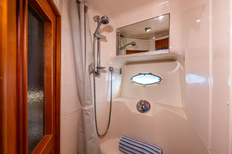 Slide: The Image of 2001 Silverton 410 Sport Bridge yacht bathroom with shower and porthole window. - 9