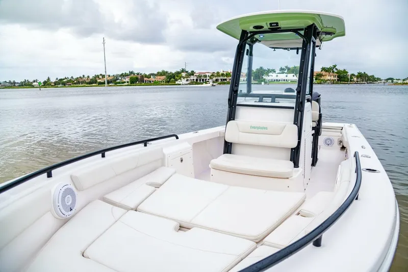 Slide: The Image of 2018 Everglades 243 Center Console boat on calm water, featuring spacious seating. - 14