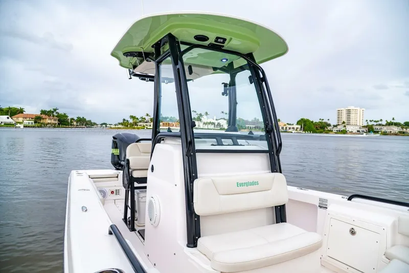 Slide: The Image of 2018 Everglades 243 Center Console boat on calm water, showcasing sleek design and seating. - 16