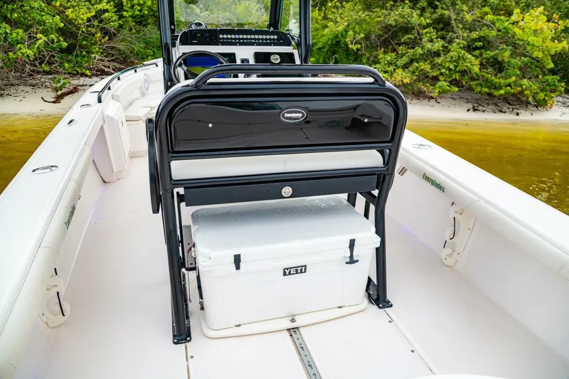 Slide: The Image of 2018 Everglades 243 Center Console boat with Yeti cooler, docked near lush shoreline. - 24