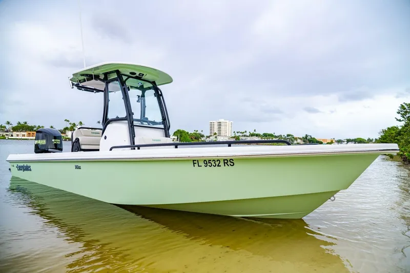 Slide: The Image of 2018 Everglades 243 Center Console boat on calm water, showcasing sleek design and Yamaha engine. - 37