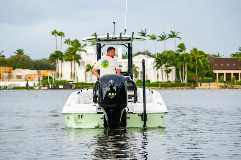Slide: The Image of 2018 Everglades 243 Center Console boat on water, with palm trees in background. - 6
