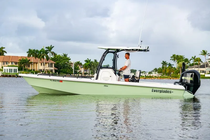 Slide: The Image of 2018 Everglades 243 Center Console boat on calm water, with palm trees in the background. - 8