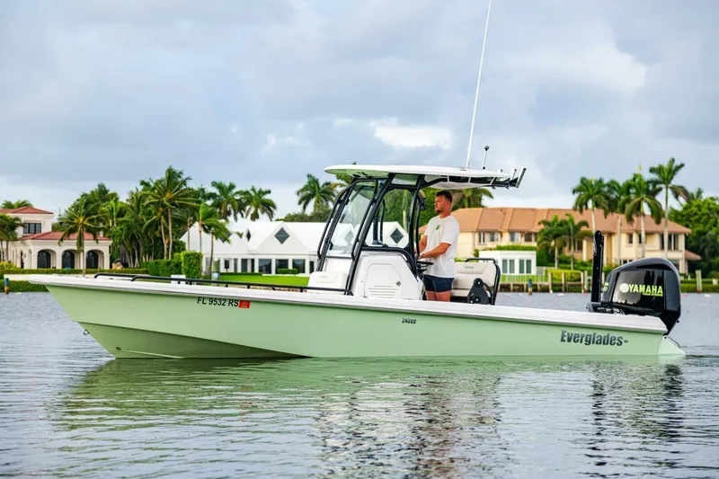 Slide: The Image of 2018 Everglades 243 Center Console boat on water, with person steering, palm trees in background. - 9