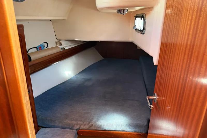 Slide: The Image of Cozy cabin interior of 2002 Bavaria 37 Sloop with blue bedding and wooden finish. - 15