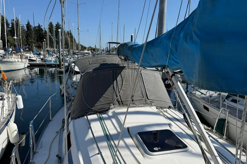 Slide: The Image of 2002 Bavaria 37 Sloop docked in a marina, surrounded by other sailboats. - 2