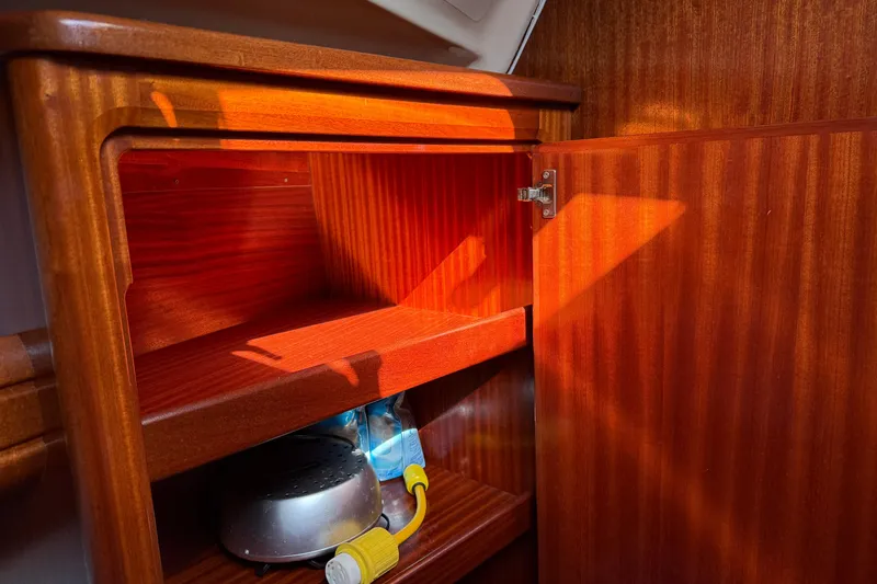 Slide: The Image of Wooden cabinet interior on a 2002 Bavaria 37 Sloop yacht, showcasing storage space. - 21
