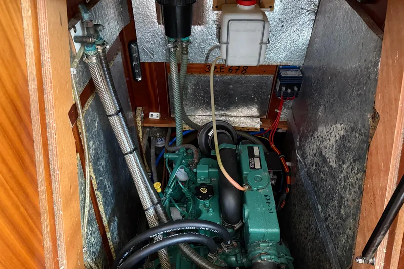 Slide: The Image of Engine compartment of a 2002 Bavaria 37 Sloop, showcasing mechanical components and wiring. - 25