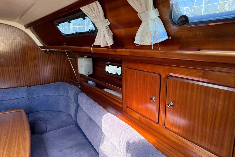 Slide: The Image of Interior of 2002 Bavaria 37 Sloop with wooden cabinetry and blue seating. - 7