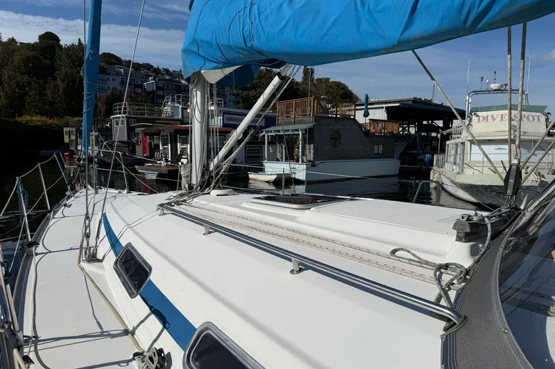 Slide: The Image of Bavaria 37 Sloop, 2002 model, docked at a marina with blue sail cover. - 9