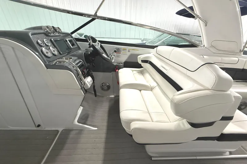 Slide: The Image of 2013 Formula 310 Bowrider interior with white leather seating and modern dashboard. - 13