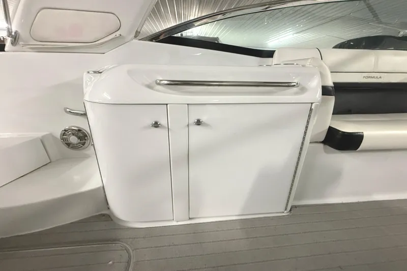 Slide: The Image of 2013 Formula 310 Bowrider interior, featuring sleek white cabinetry and seating. - 19
