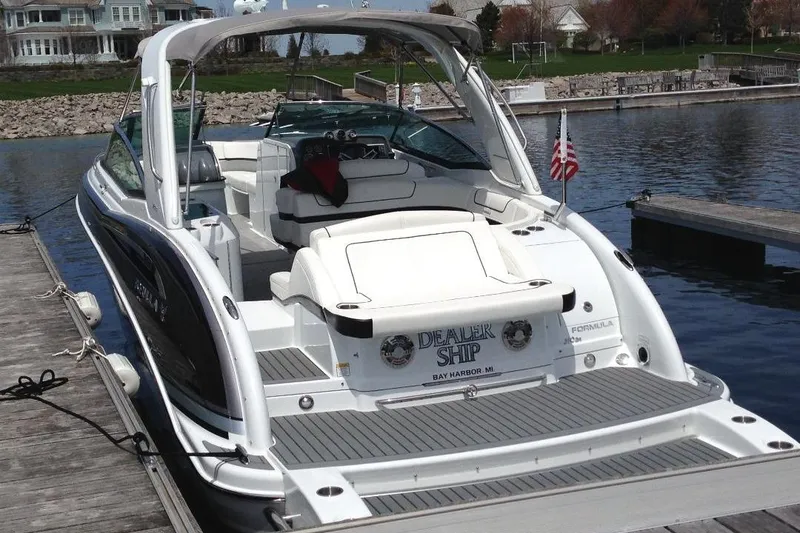 Slide: The Image of 2013 Formula 310 Bowrider docked at marina, featuring spacious seating and sleek design. - 3