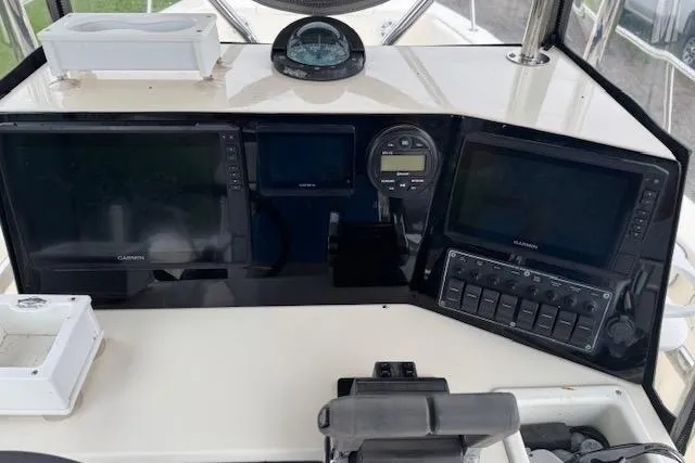 Slide: The Image of 1997 Sea Cat 255 boat dashboard with Garmin navigation systems and compass. - 15