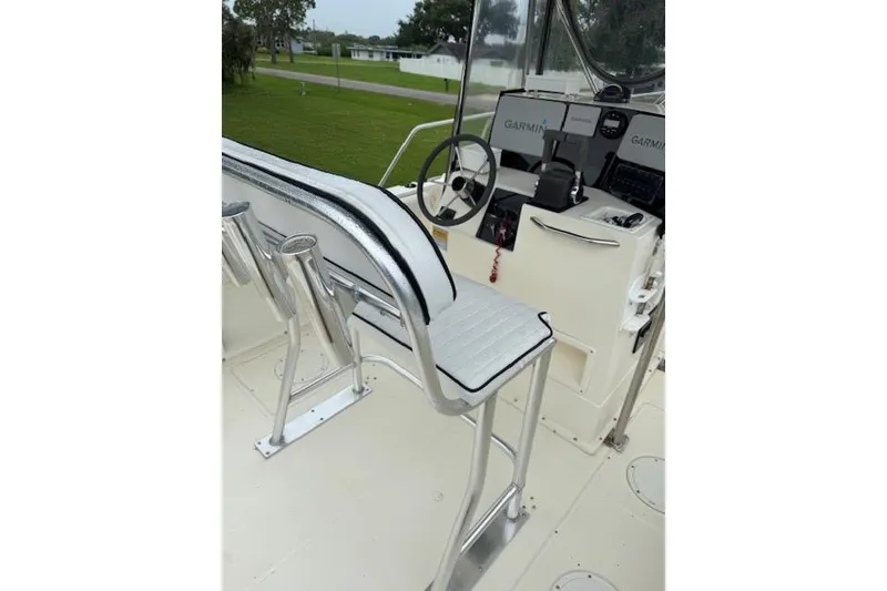 Slide: The Image of 1997 Sea Cat 255 boat interior with steering wheel and Garmin navigation system. - 18